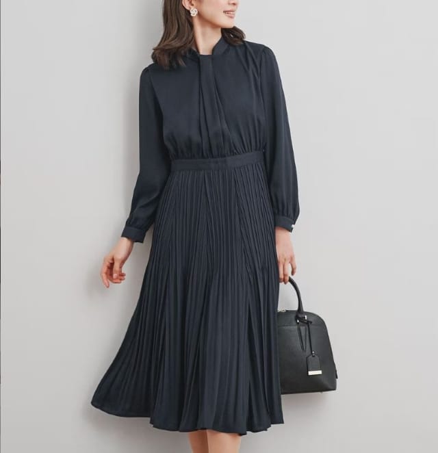 ハイネックとプリーツスカートが上品なネイビーワンピースのフォーマルコーデ