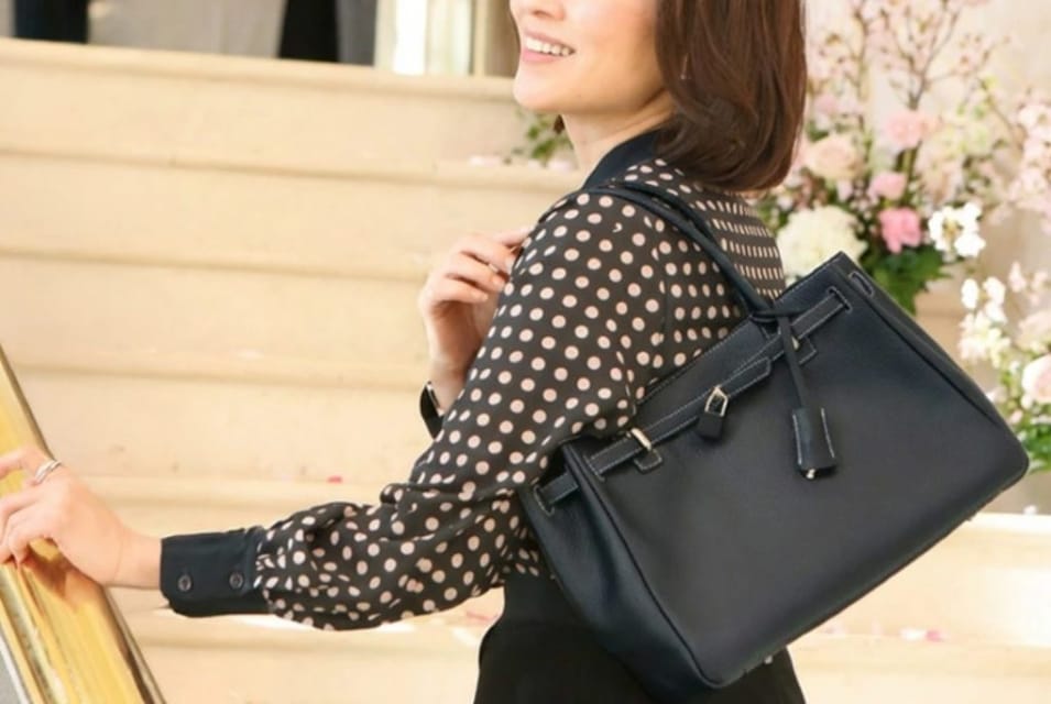 卒業式や学校行事に合う上品な黒のブランドバッグを持つ40代ママ