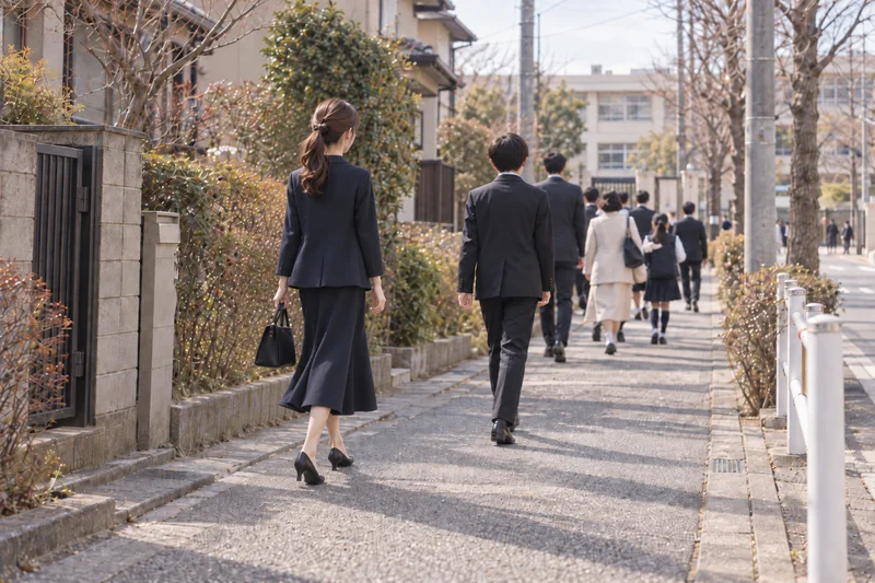 卒業式の朝、パンプスで子どもと学校へ歩いて向かうママ