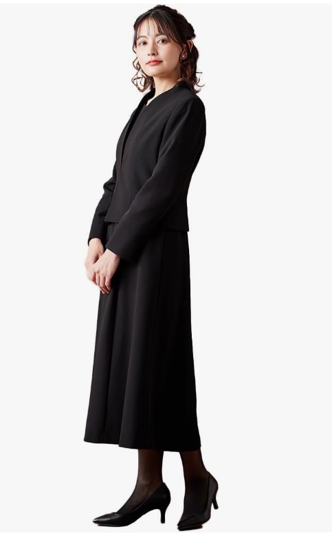 黒の喪服アンサンブルを着た女性の横向き全身コーディネート写真｜上品で落ち着いた印象