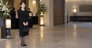 40代女性の喪服姿、斎場ロビーで佇む様子