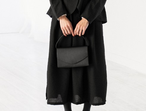 ナチュラル系フォーマルスーツと黒バッグの組み合わせ 落ち着いた印象の喪服スタイル