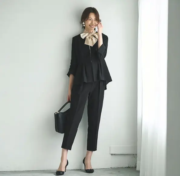 七五三におすすめの黒ペプラムトップスとパンツのセットアップを着た30代女性