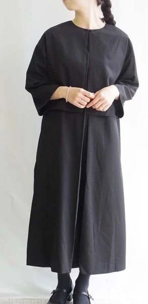 黒のゆったりしたノーカラージャケットとロングワンピースを合わせた女性のナチュラルフォーマルコーディネート