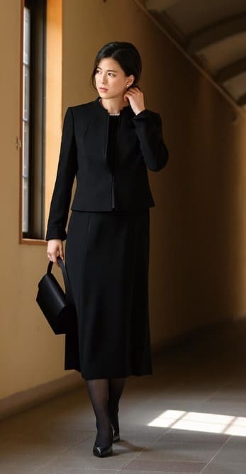 ロング丈アンサンブルの喪服を着た女性