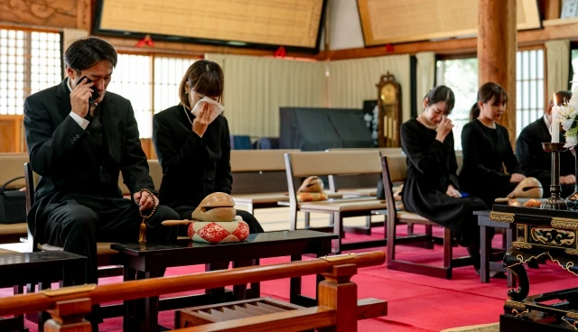 和室の会館で焼香する喪服姿の参列者たち｜家族葬のイメージ