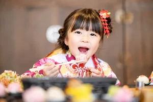 着物姿で七五三の食事会を楽しむ女の子