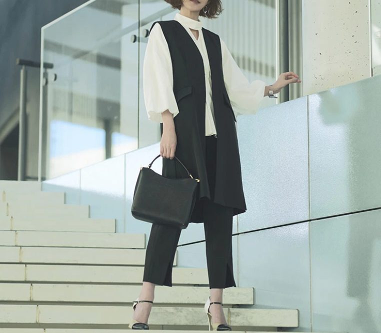 黒のロングジレとパンツのセットアップを着たセレモニーコーデ女性