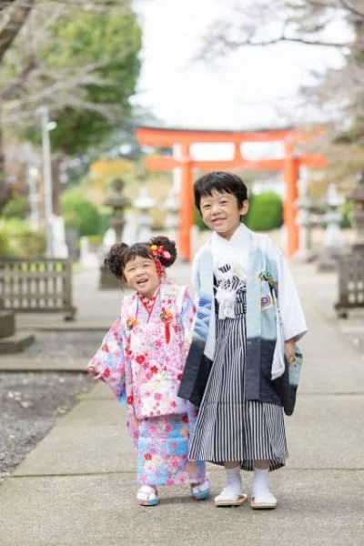鳥居の前で七五三のお参りをする兄妹