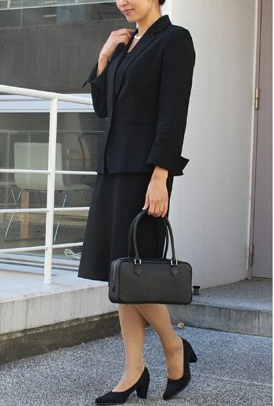 ブラックフォーマルの喪服を着た女性のコーディネート（ジャケットとワンピース、フォーマルバッグ）