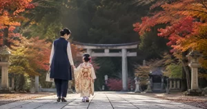 七五三の境内でジレスーツを着た母親が子どもと歩いている様子