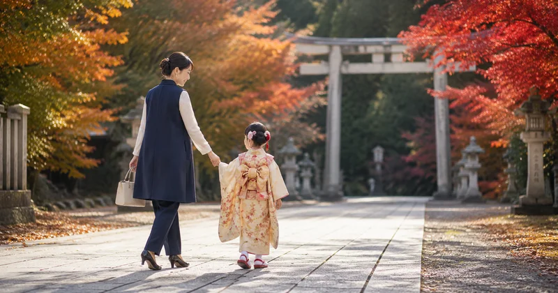 七五三の境内でジレスーツを着た母親が子どもと手をつないで歩く様子